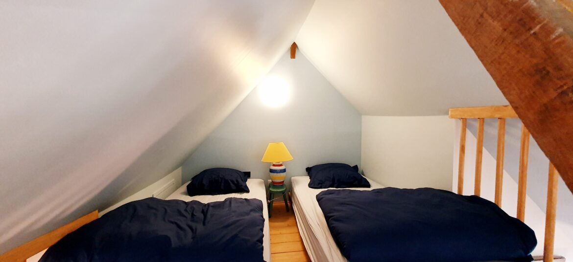 Deux lits en mezzanines accessibles par une échelle de meunier recommandée à partir de 7 ans
